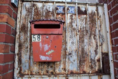 Close-up of old mailbox on rusty door