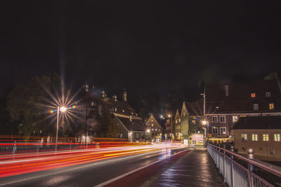 Light trails on road against sky at night