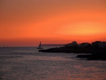 Boat sailing in sea at sunset