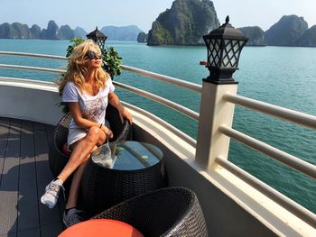 Woman sitting in boat against sea