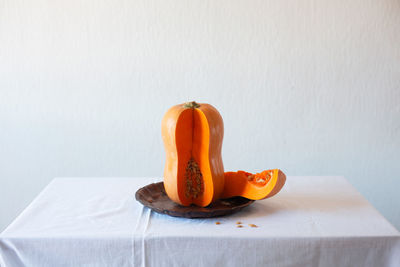 Close-up of pumpkin on table against wall