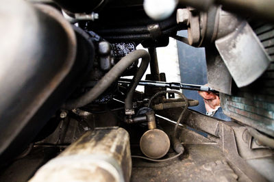 Close-up of mechanic working on car engine