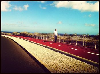 Empty road against cloudy sky