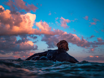Man swimming in sea during sunset