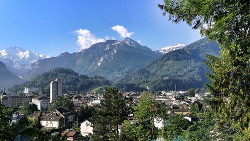 Aerial view of townscape and mountains against sky