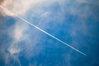 Low angle view of vapor trail in blue sky