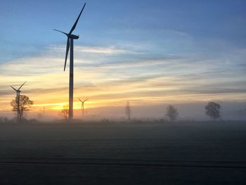 Silhouette of wind turbines at sunset