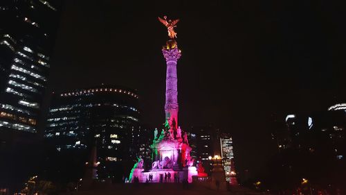 Low angle view of illuminated tower against sky at night