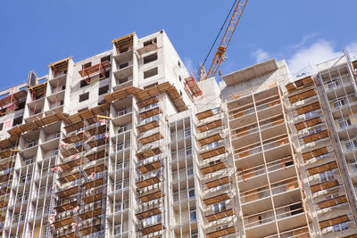 A construction crane and a new skyscraper are under construction