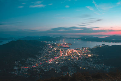 High angle view of illuminated cityscape against sky at night