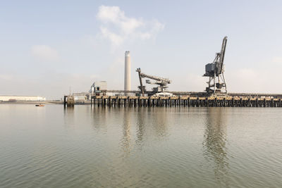 Lpg terminal pier in thames river against sky