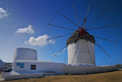 Low angle view of traditional windmill against blue sky