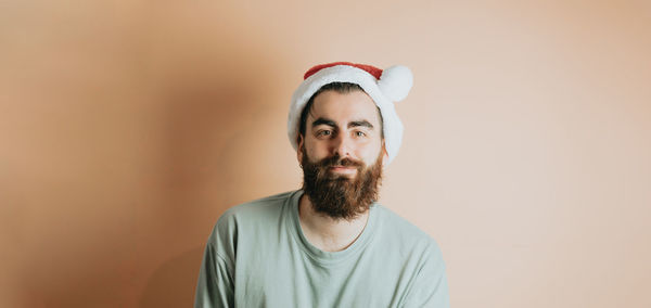 Man with santa hat against wall