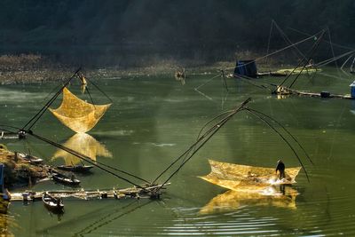 Man on fishing net at lake