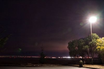 Illuminated trees against sky at night