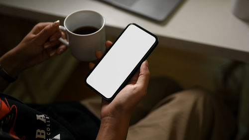 Midsection of man using mobile phone