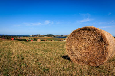 Hay bales on field against sky