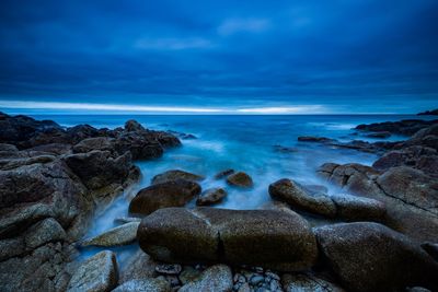 Rocks on sea shore against sky