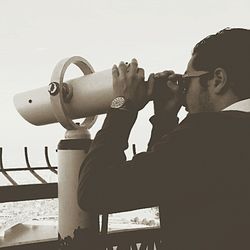 Close-up of a man with camera against sky