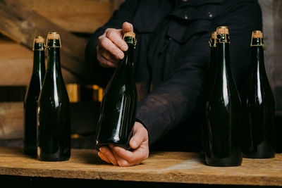 Midsection of man drinking glasses on table