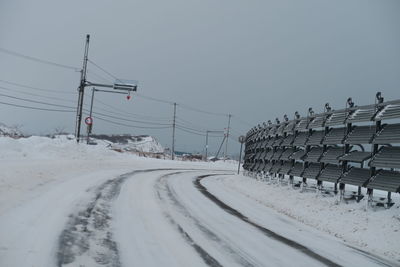 Snow covered road against clear sky