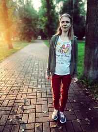 Portrait of girl standing on footpath
