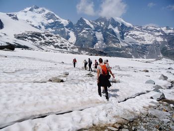 People on snowcapped mountain against sky