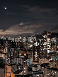 Illuminated cityscape against sky at night