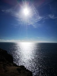 Scenic view of sea against bright sun