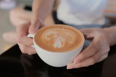 Midsection of woman holding coffee cup