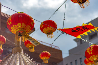 Low angle view of lanterns hanging against sky