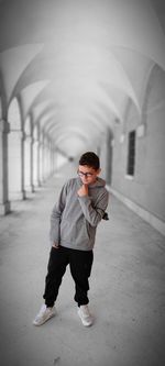 Full length of boy standing in corridor