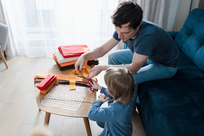 Cute preschooler boy and dad making diy snuffle mats for their pets, domestic cat and dog