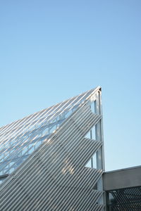 Low angle view of modern building against clear blue sky