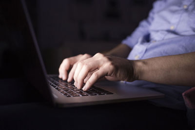 Man working at night, using laptop