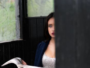 Portrait of woman reading newspaper while siting outdoors