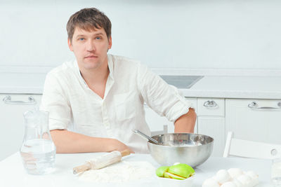 Portrait of young woman preparing food at home