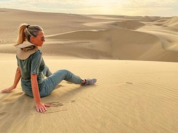 Full length of man on sand dune in desert