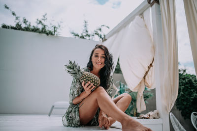 Portrait of a smiling young woman sitting outdoors