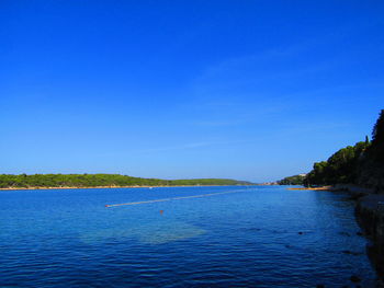 Scenic view of sea against clear blue sky
