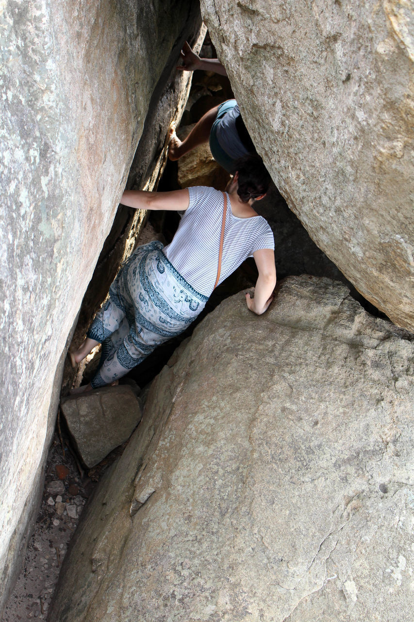 HIGH ANGLE VIEW OF SENIOR MAN ON ROCKS