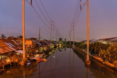 Bridge over canal in city against sky