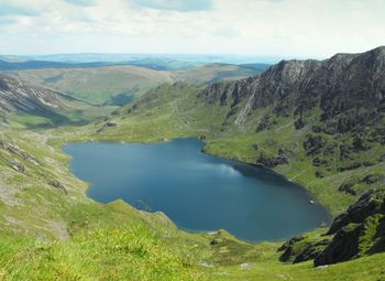 Scenic view of lake by mountains against sky