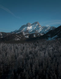 Scenic view of snowcapped mountains against blue sky