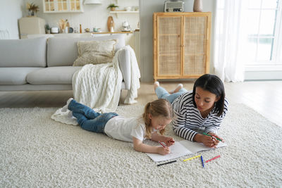 High angle view of boy playing with teddy bear at home