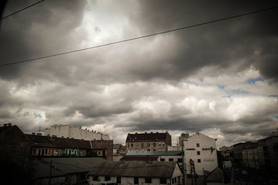 Low angle view of buildings against cloudy sky