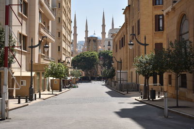 Street amidst buildings against sky in city