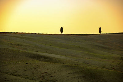 Scenic view of field against clear sky during sunset