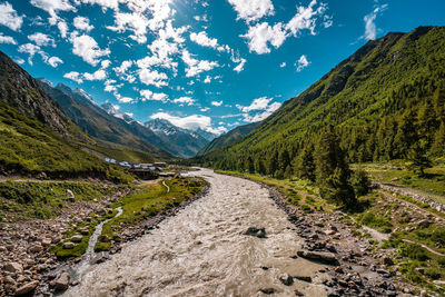 Road leading towards mountains against sky