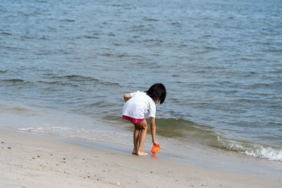 Rear view of boy standing on beach